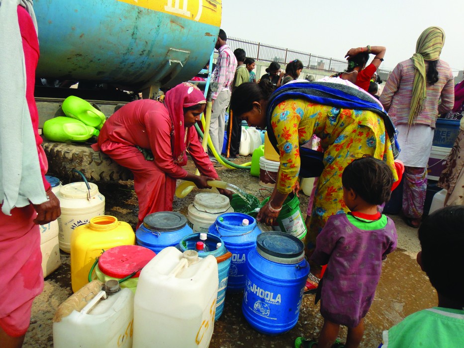 Women and children collect drinking water from tanks in India