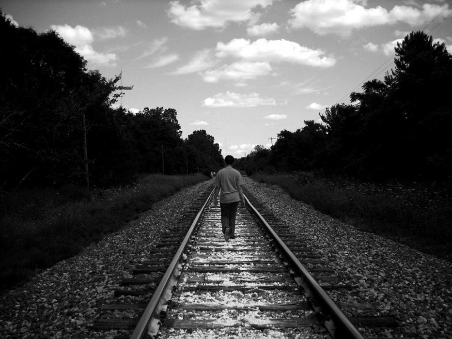 Person walking alone on train tracks